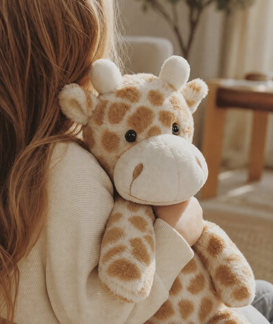 A child holding her heartbeat giraffe stuffed keepsake